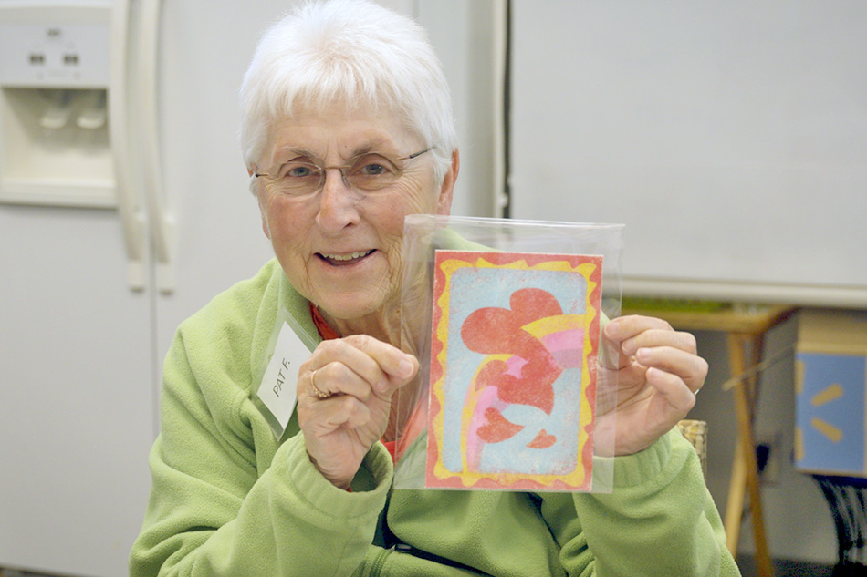 Senior lady holding up craft artwork