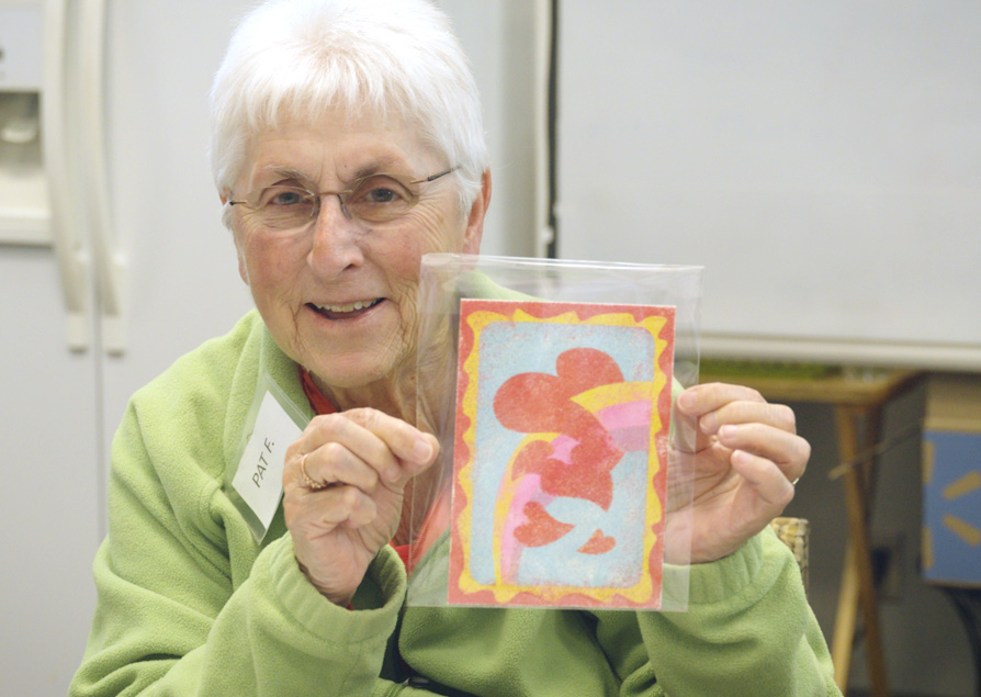 Senior lady holding up artwork